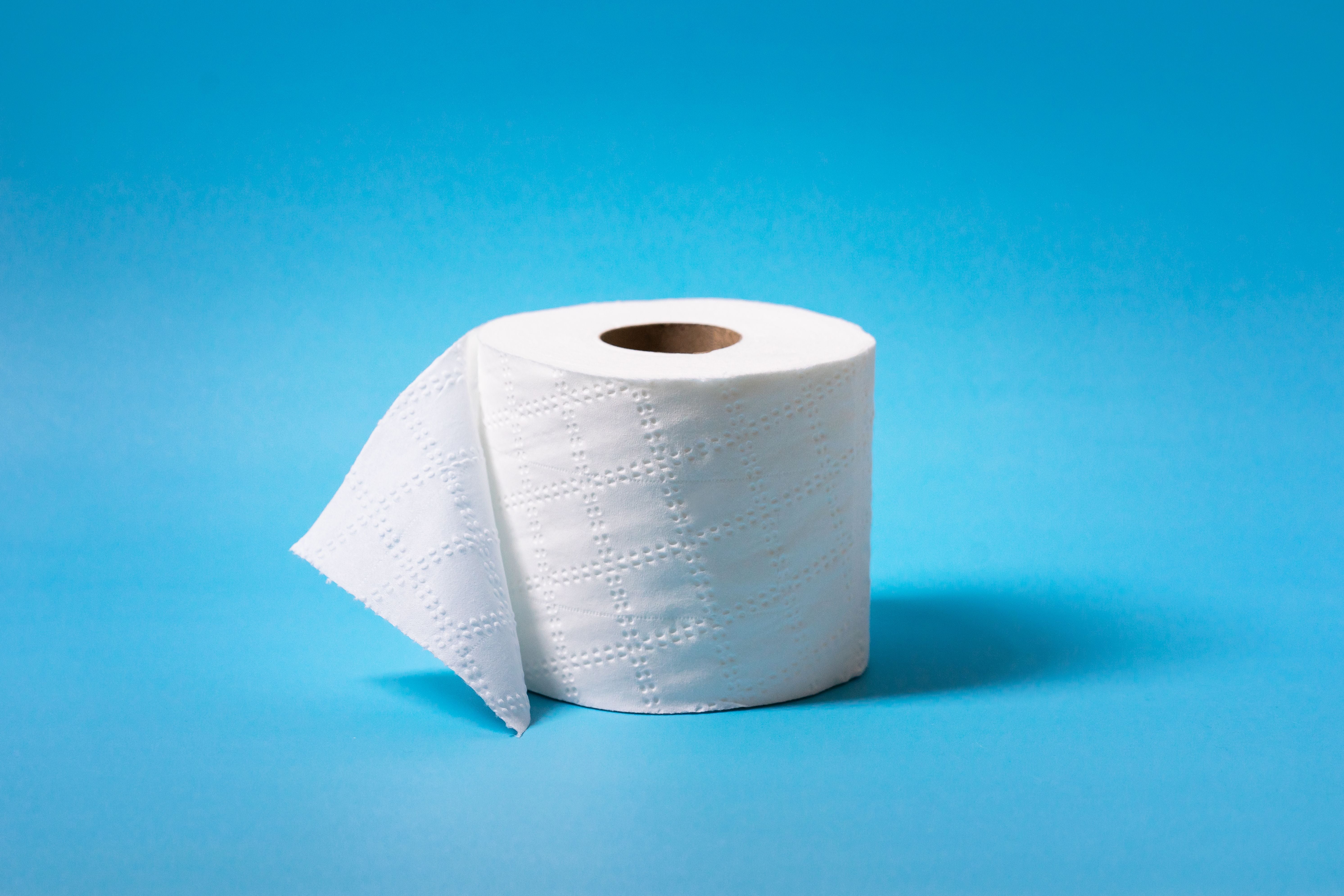 Toilet paper against a soft blue background